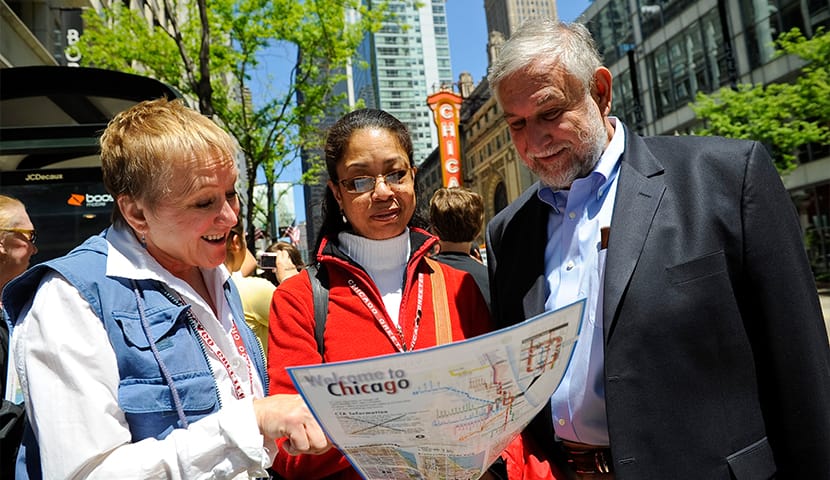 A group of travelers look at a map on Chicago’s State Street.